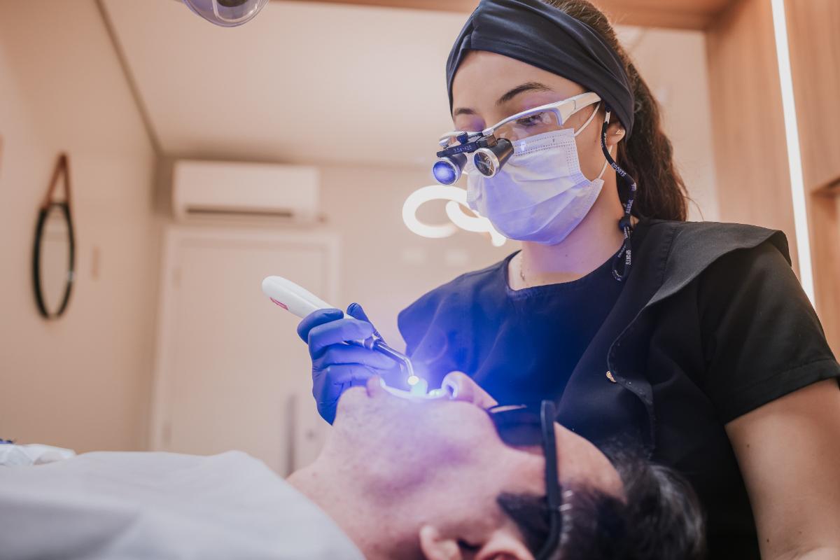 Atendimento com magnificação e fotopolimerizador na SB Odontologia